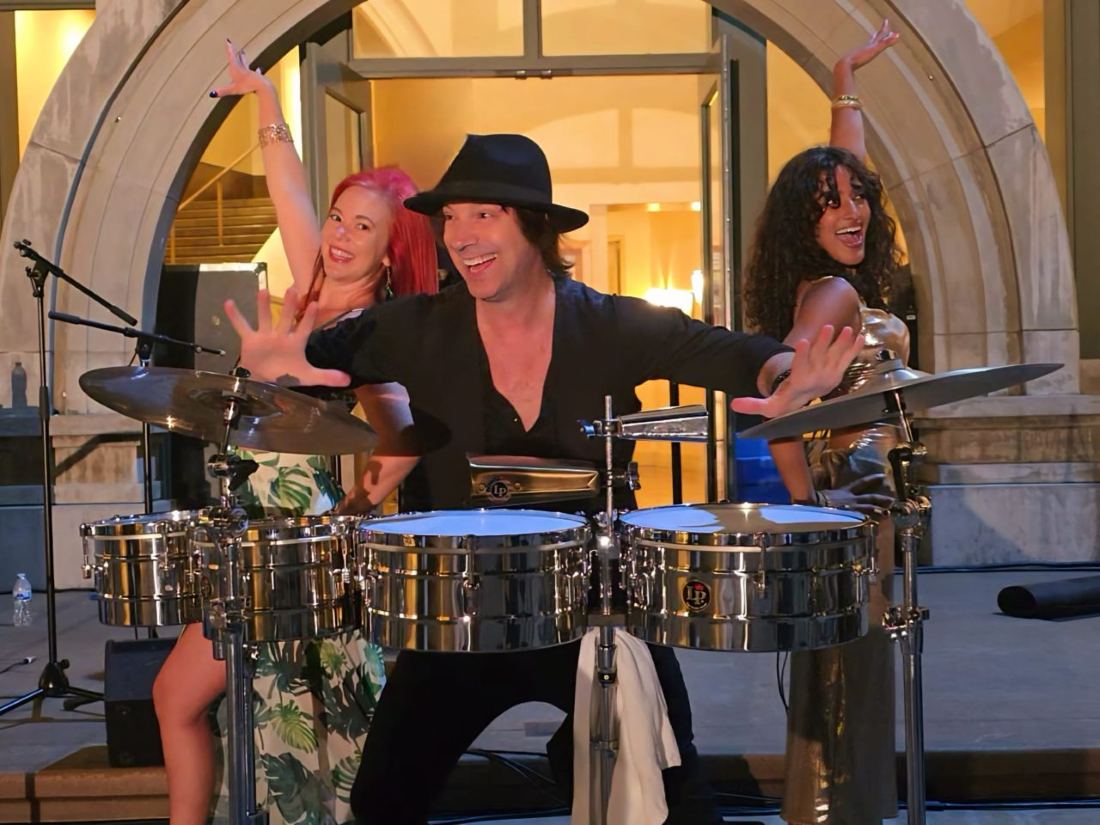 Michael on percussion with dancers performing at an upscale event