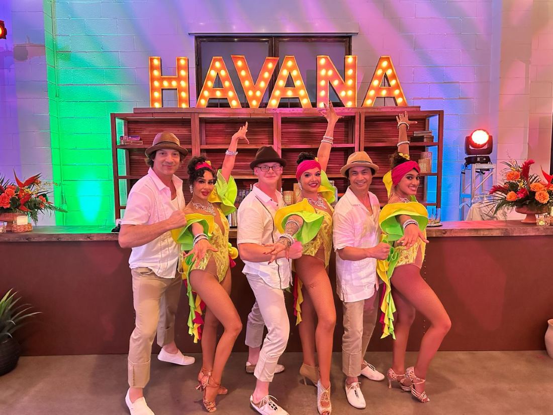 The Positive Energy performance team in themed costumes in front of a Havana marquee